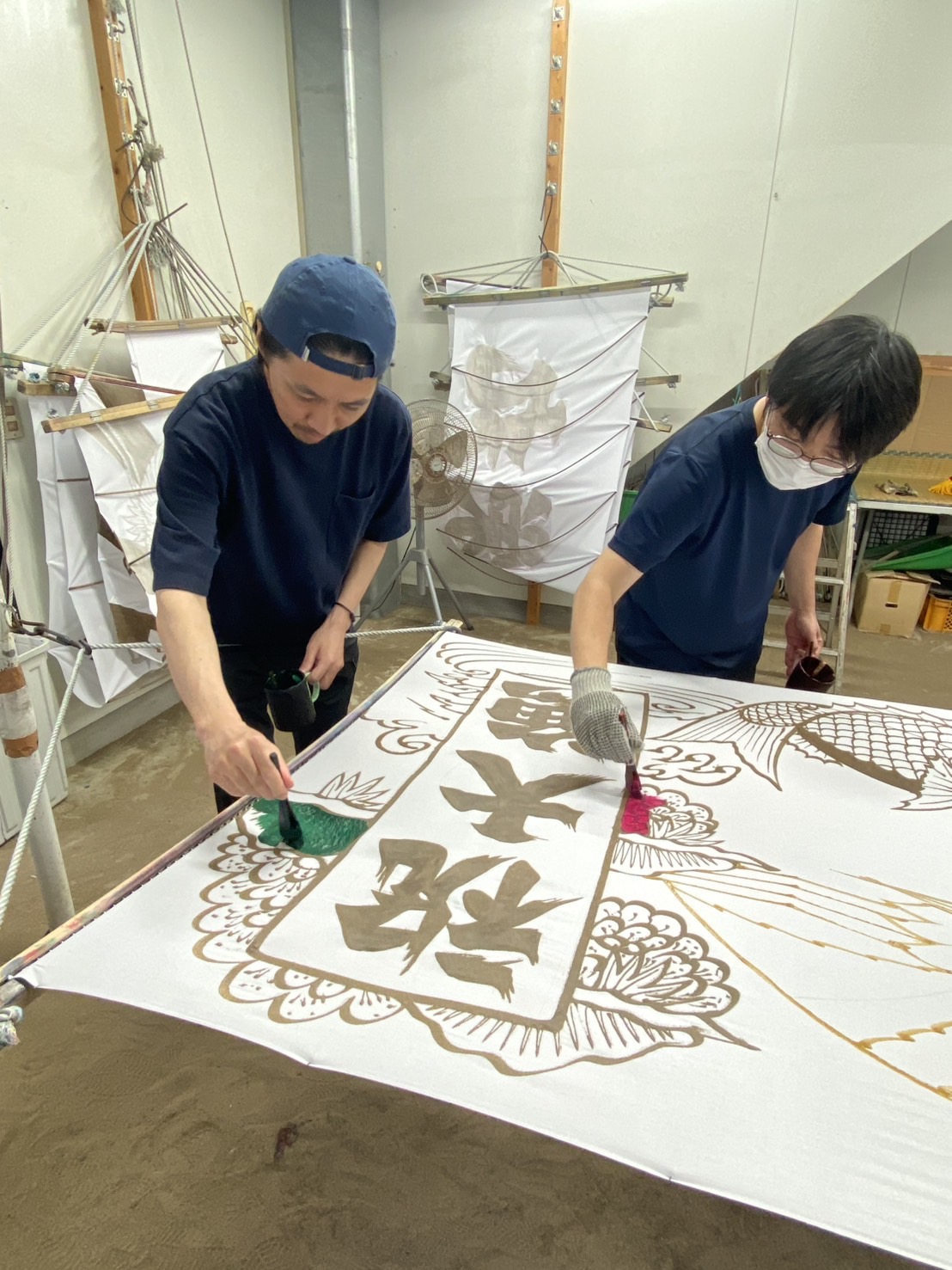 小澤染工場で職人が大漁旗を手染めしている様子